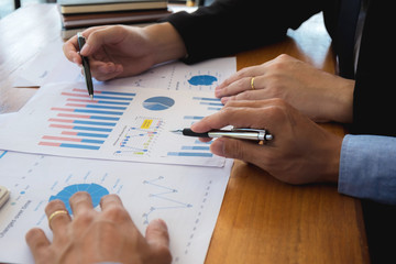 Sitting and working, consulting and suggesting work, checking work reports with a calculator in a business office.