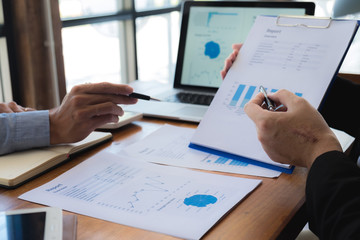 Sitting and working, consulting and suggesting work, checking work reports with a calculator in a business office.