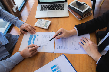 Sitting and working, consulting and suggesting work, checking work reports with a calculator in a...