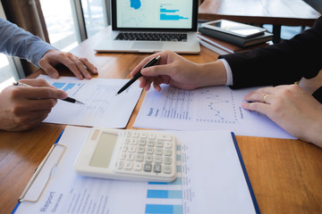Sitting and working, consulting and suggesting work, checking work reports with a calculator in a...