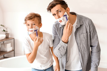 Father and his little son shaving in bathroom