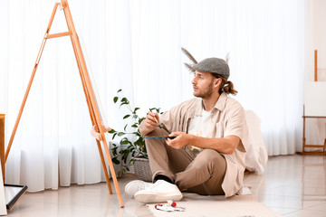 Young male artist working in studio