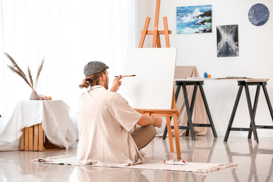 Young male artist working in studio