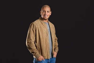 Stylish African-American man on dark background