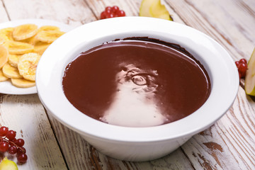 Bowl with tasty chocolate fondue on table