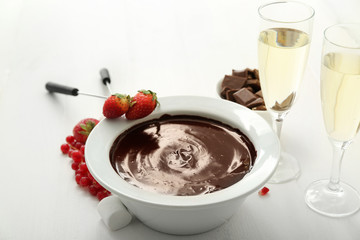 Bowl with tasty chocolate fondue, berries and marshmallow on table