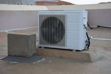 Exterior air conditioner unit on the top of a residential house roof. Contruction, DIY, hot weather, industrial systems, concepts.