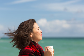 Portrait of a happy Asian woman drinking coffee.
