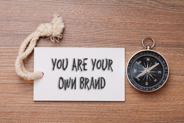 You are your own brand - business tips handwriting on label with compass