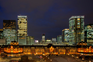 Tokyo Railway Station, beautiful urban cityscape surrounding by modern high-rise buildings in Marunouchi business district, during twilight against cloudy sky.