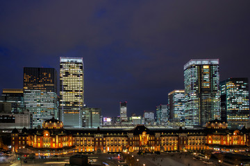 Tokyo Railway Station, beautiful urban cityscape surrounding by modern high-rise buildings in Marunouchi business district, during twilight against cloudy sky.