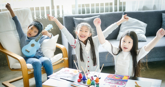Asian family with cute kids painting art in living room at home