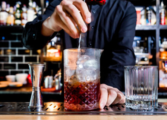 Bartender is making cocktail at bar counter. Fresh cocktails. Barman at work. Restaurant. Nightlife.