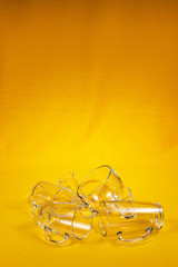 Glassware different in volume and shape on a bright yellow fabric