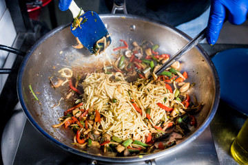 Chef cooking pasta with vegetables in pan. Italian style cuisine. Restaurant.