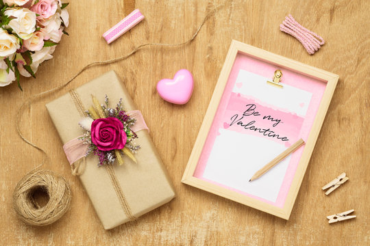 Mockup Blank photo frame for Valentines day concept. Top view of mock up photo frame with beautiful craft gift box decoration and rose flowers on grunge wood background.