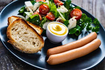 Continental breakfast - boiled sausages, toasts and greek salad