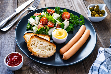 Continental breakfast - boiled sausages, toasts and greek salad