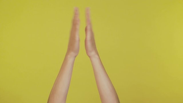 Woman hands waving, dancing snaps her fingers to music rhythm gesture isolated over yellow background in studio. Copy space for advertisement. 4K