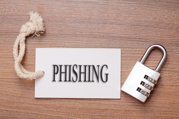 Combination number padlock on wood background with phishing written on label tag