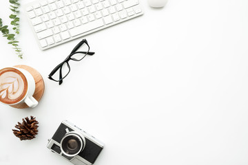 White minimal photographer desk table with retro film camera, computer tools, cup of latte coffee...