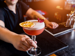 Bartender is making cocktail at bar counter. Fresh cocktails. Barman at work. Restaurant. Nightlife.