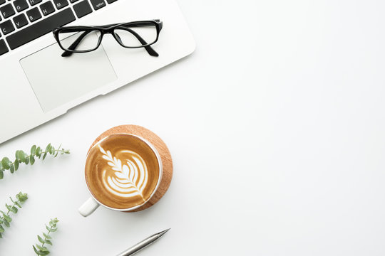 White Minimalist Office Desk Table With Laptop Computer, Cup Of Latte Cofee And Supplies. Top View With Copy Space, Flat Lay, Minimal Style.