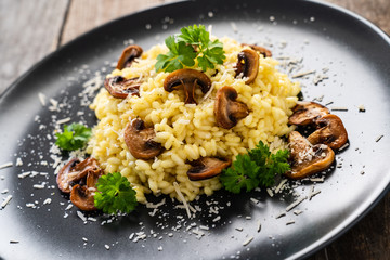 Risotto with champignon and  parmesan on wooden background
