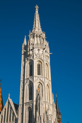 Fototapeta na wymiar Bell tower of Matthias Church, a Roman Catholic church in front of theFisherman's Bastion at the heart of Buda's Castle District