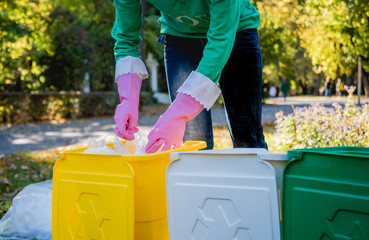 Volunteer girl sorts garbage in the street of the park. Concept of recycling. Zero waste concept. Nature