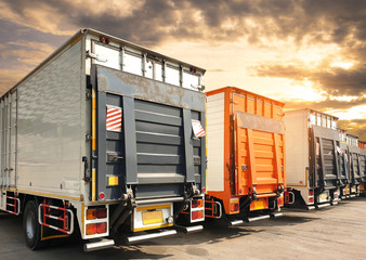 trucks parking at sunset sky, freight industry delivery shipment transport.