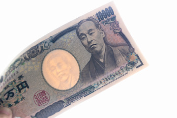 Ten thousand Japanese Yen banknotes on hand isolated on white background.
