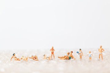Miniature people wearing swimsuit relaxing on bubble  , vacation concept