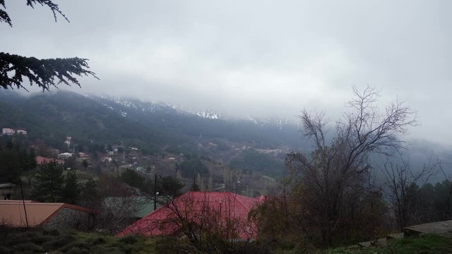 4K. View of winter mountain Troodos in Cyprus. Pan from foot of the mountain with red tile roof