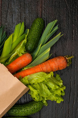 organic vegetables. bag of products on a dark wooden background. Crop agronomist from the garden. Fresh vegetables in the bag, healthy food for vegetarians