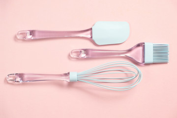 Blue silicone backing utensils on pink background, top view