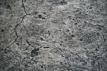 Texture of an old cracked concrete wall. Background image of a worn gray concrete surface