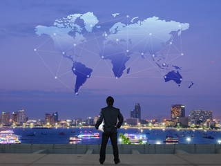 businessman stand on roof top of skyscrabber with globalization concept item on sky