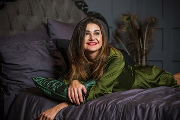 Fototapeta premium Woman in dark boudoir interior and silk green robe