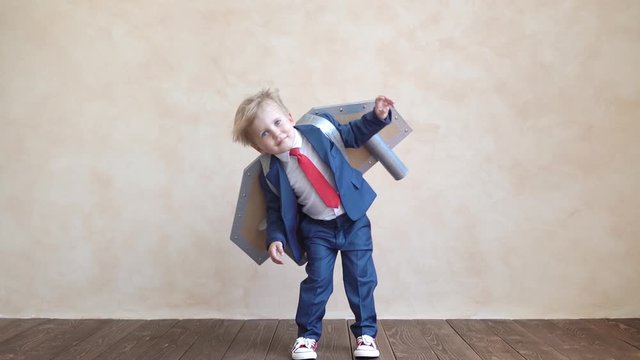 Happy child with toy paper wings. Slow motion