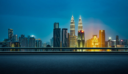 Empty asphalt road with beautiful night cityscape scene .