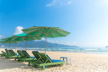 Beach chairs with outdoor umbella at summer beach.