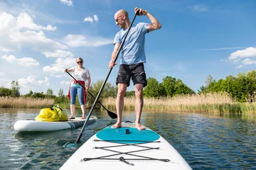 Foto op Canvas Couple on stand up paddle board on the lake, SUP © David.Sch
