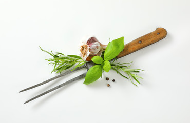 Old carving fork, garlic, herbs and peppercorns