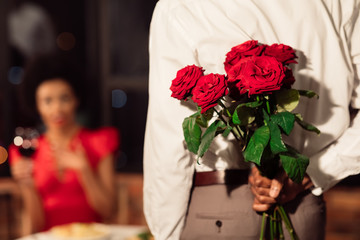 Boyfriend Holding Bouquet Of Roses Congratulating Girlfriend In Restaurant