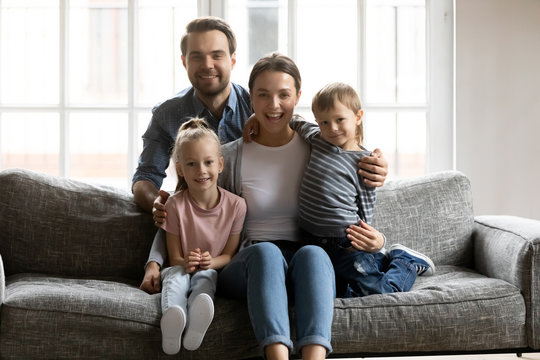 Portrait of happy family with kids relax on sofa