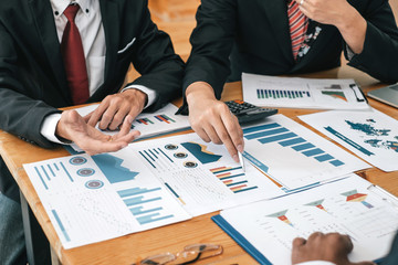 Business people discuss together about the data graph of the business that invest.