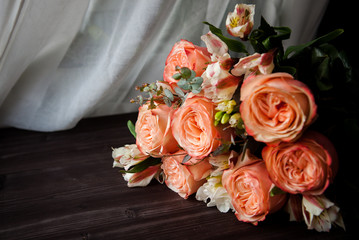 large luxurious bouquet of peony roses of coral color with white freesia in noir style on a dark background.  white drapery. dark romance