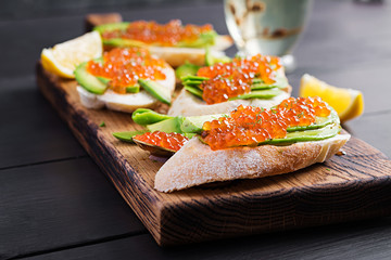 Sandwiches with salmon red caviar with sliced avocado. Sandwich for lunch. Premium food.