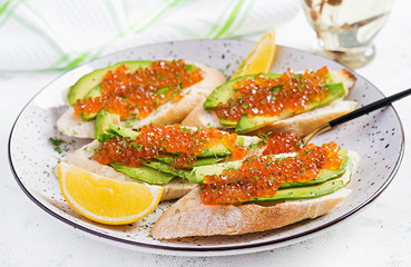 Sandwiches with salmon red caviar with sliced avocado. Sandwich for lunch. Premium food.